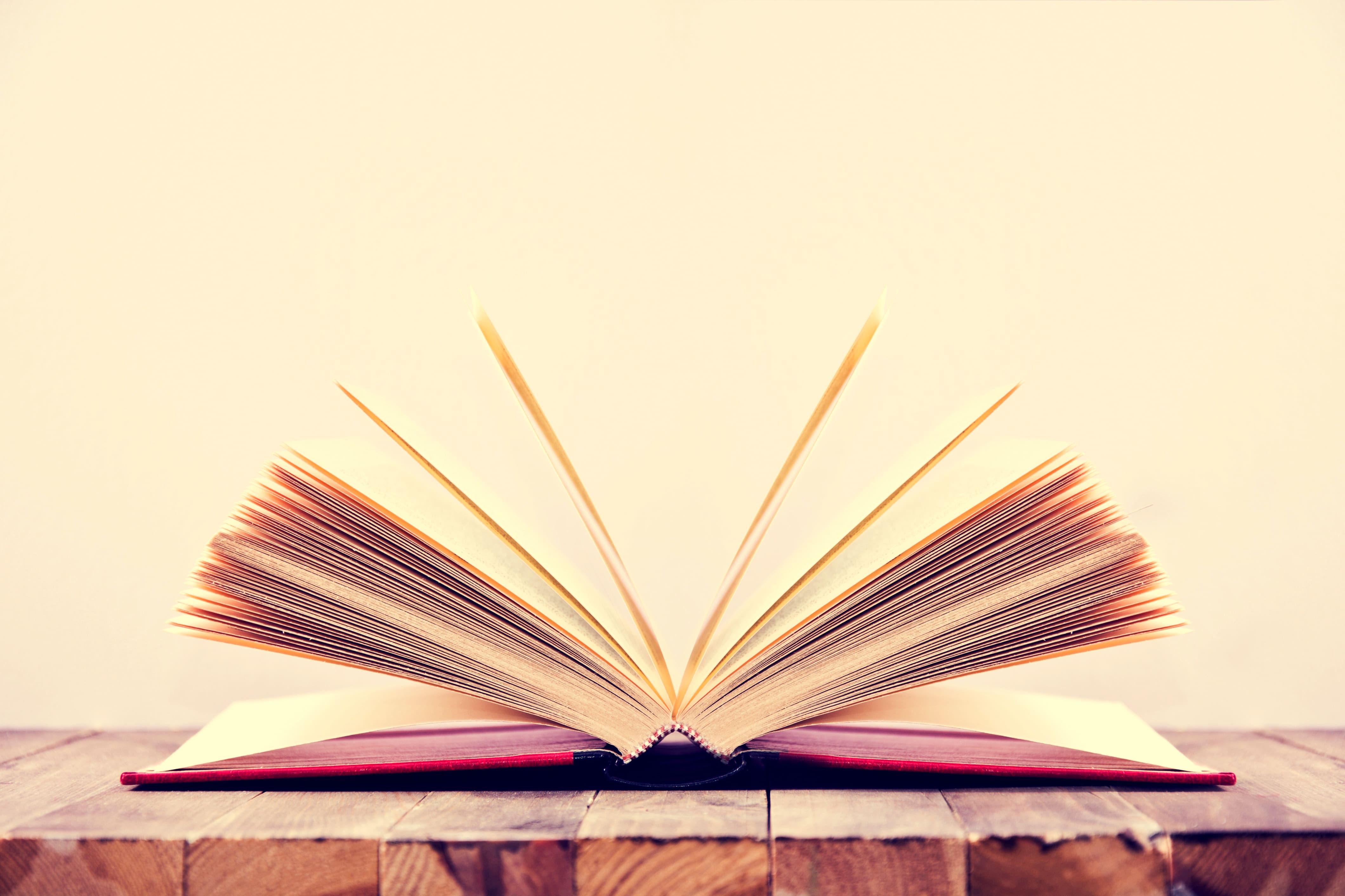 Illustratie van een open boek met zwevende ideeën en iconen